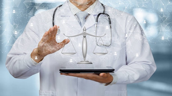Le médecin montre la balance de la justice de la gestion des ressources sur la tablette - Gérer les tâches administratives médicales - Serenity
