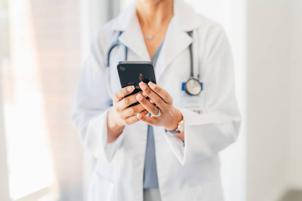 les mains d'un médecin tenant un téléphone dans la main - externaliser les appels téléphoniques médicaux - Serenity