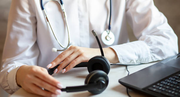 un médecin tenant un microcasque sur son bureau - télésecrétariat externalisé - Serenity