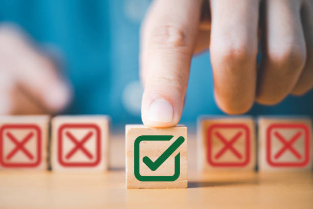 Une main poussant le symbole du signe vert correct devant le signe de la Croix-Rouge sur un bloc de bois cube - standard téléphonique externalisé - Serenity