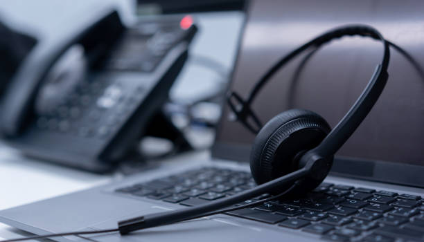 casque noir en gros plan sur un ordinateur portable et un téléphone - call center médical - Serenity