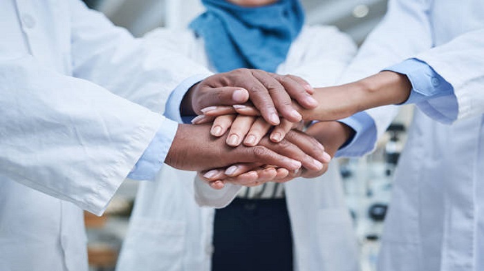 Plan d'un groupe de scientifiques se donnant la main en signe de solidarité - expérience client médical - Serenity