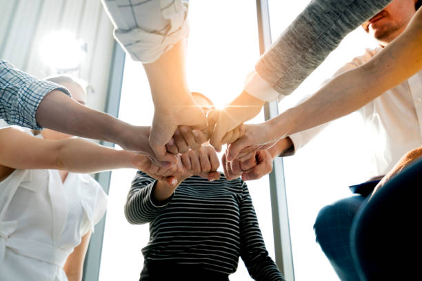 hommes d'affaires jeunes et dynamiques, joignant leurs mains - Événements internes en entreprise - Serenity