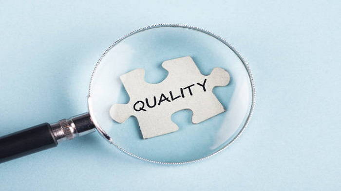 Le mot Qualité sur une pièce de puzzle avec une loupe - Embaucher une secrétaire téléphonique médicale - Serenity