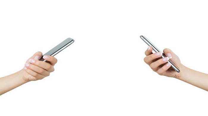 Deux mains tenant des téléphones portables - fidélisation des patients - Serenity