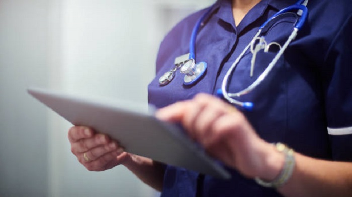 un professionnel de santé anonyme tapant sur une tablette - gestion des agendas des médecins - Serenity