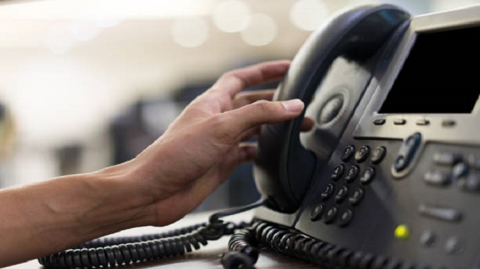 un employé touchant le combiné du téléphone - organiser un cabinet médical - Serenity  